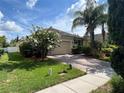 Charming house with a brick driveway and lush landscaping, showcasing vibrant greenery and curb appeal at 12728 Boggy Pointe Dr, Orlando, FL 32824