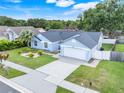 Beautiful single-story home with a well-kept lawn, mature trees, and a two-car garage at 1322 Ravida Woods Dr, Apopka, FL 32703