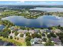 Aerial view of a home with a lake in the background, showcasing the property lines at 13838 Bluebird Park Rd, Windermere, FL 34786