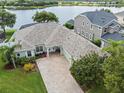 An aerial view of a well-maintained home showing the driveway, landscape and access to a lake at 13838 Bluebird Park Rd, Windermere, FL 34786