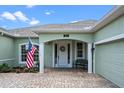 Inviting home entrance with white columns, a beautiful door with a wreath, and a quaint bench at 13838 Bluebird Park Rd, Windermere, FL 34786