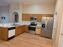 Traditional kitchen with stainless steel appliances, wood cabinets, and a breakfast bar at 1797 Tillstream Dr, Orlando, FL 32818