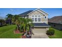 Two-story home with well-manicured lawn, front yard landscaping, and a two-car garage at 2530 The Oaks Blvd, Kissimmee, FL 34746