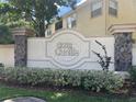 Sign for Club Cortile featuring stone accents and lush landscaping in a well-maintained community at 2770 Club Cortile Cir # A, Kissimmee, FL 34746