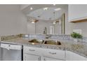 Close-up of a stainless steel sink with granite countertops and white cabinets at 3196 Verbena Ct, Deltona, FL 32725