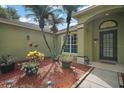 A beautifully landscaped front entrance features palm trees, various plants, and solar lighting at 3271 Settlers Trl, St Cloud, FL 34772
