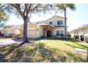 Charming two-story home with a two-car garage, stone accents, and lawn at 331 Bridgewater Dr, Davenport, FL 33897