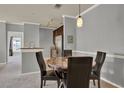 Dining area with a round table, four chairs, pendant lighting, and views into kitchen and living areas at 3757 Conroy Rd # 2525, Orlando, FL 32839