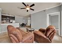 Living room featuring neutral walls, plush armchairs, ceiling fan, and an open layout to the kitchen at 3757 Conroy Rd # 2525, Orlando, FL 32839