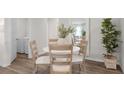 Bright dining area features wood floors, round white table with 4 chairs, and indoor plants for a fresh look at 5202 Orchard Oriole Loop, Bartow, FL 33830