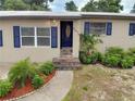 Close-up shot of the inviting front entrance with a blue door and landscaped garden at 5615 Arundel Dr, Orlando, FL 32808