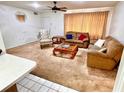 Bright living room featuring plush carpeting, comfortable seating, and a decorative ceiling fan at 8547 Cedar Cove Dr, Orlando, FL 32819
