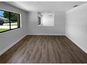 A spacious living room is filled with natural light from the large window, with sleek wood floors throughout at 9744 Tattersall Ave, Orlando, FL 32817