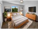 Cozy main bedroom with a comfy bed, stylish nightstands, and a dresser with a mounted TV at 9744 Tattersall Ave, Orlando, FL 32817