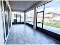 Spacious enclosed patio with sliding glass windows, offering panoramic views of the backyard and surrounding landscape at 1023 Sugarwood St, Davenport, FL 33837