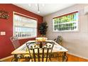Dining room with red accent wall, wood floors, decorative chairs, and views of exterior at 130 Masterpiece Rd, Lake Wales, FL 33898