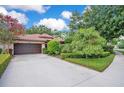 Charming home exterior showcases beautiful landscaping, a spacious driveway, and a terra cotta tiled roof at 1609 Glen Eagles Way, Orlando, FL 32804
