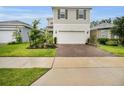Attractive two-story home showcasing a two-car garage and well-maintained landscaping with a brick-paved driveway at 17426 Saw Palmetto Ave, Clermont, FL 34714