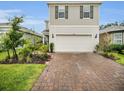 Beautiful two-story home with a two-car garage and a brick-paved driveway, complemented by lush landscaping at 17426 Saw Palmetto Ave, Clermont, FL 34714