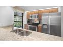 Bright kitchen with stainless steel appliances, granite countertops, and a window overlooking the outdoors at 199 Heron Bay Cir, Lake Mary, FL 32746