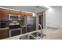Modern kitchen featuring granite countertops, stainless steel appliances, and dark wood cabinets at 199 Heron Bay Cir, Lake Mary, FL 32746