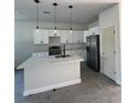 Modern kitchen with white cabinets, a center island, pendant lighting, and stainless steel appliances at 230 Lucile Way, Orlando, FL 32835