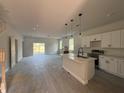 Open-concept kitchen featuring stainless steel appliances, an island, and ample natural light at 230 Lucile Way, Orlando, FL 32835