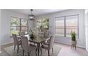 Elegant dining room with large windows, modern light fixture, neutral decor, and wood-look floors at 2444 Omaha Dr, Deltona, FL 32738