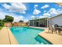 Swimming pool in backyard, surrounded by lounge chairs and screened lanai with patio seating at 3024 Saratoga Dr, Orlando, FL 32806
