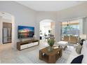 Inviting living room showcasing tile floors, a TV, and seamless access to the dining and outdoor spaces at 315 Belhaven Falls Dr, Ocoee, FL 34761