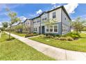 View of a row of townhomes with well-maintained lawns and sidewalks on a sunny day at 3303 Azolla St, Orlando, FL 32808