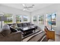Bright living room features large windows, modern decor, ceiling fan, and comfortable gray sectional at 3303 Azolla St, Orlando, FL 32808