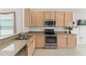 Spacious kitchen with stainless steel appliances and light wood cabinets at 3419 Fernwood Dr, Kissimmee, FL 34741
