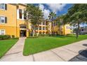 Exterior view of yellow apartment building with sidewalk and green lawn at 3707 Conroy Rd # 1715, Orlando, FL 32839