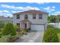 Charming two-story home features red trim, a well-manicured lawn, and an attached two-car garage at 404 Bar Ct, Kissimmee, FL 34759