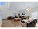 Bright living room features neutral walls, recessed lighting and a dining area with an elegant light fixture at 404 Bar Ct, Kissimmee, FL 34759