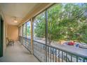 View from porch overlooking the street and surrounding greenery, with chairs and a ceiling fan at 506 Mirasol Cir # 202, Celebration, FL 34747