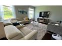 Living room featuring a comfortable sectional sofa, a plush rug, and large windows offering scenic views at 5169 Dove Tree, Orlando, FL 32811