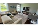 Living room featuring a comfortable sectional sofa, a plush rug, and large windows offering scenic views at 5169 Dove Tree, Orlando, FL 32811