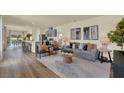 Open-concept living room with modern decor, wood-look floors, and natural light at 5250 Scrub Mint Ln, Apopka, FL 32712