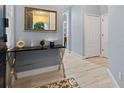 Stylish foyer with tiled floor, decorative table, mirror, and white doors at 6027 Strada Isle Way, Orlando, FL 32835