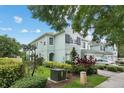 Charming two-story townhome featuring manicured landscaping, lush green grass, and ample parking at 6027 Strada Isle Way, Orlando, FL 32835
