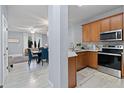 Modern kitchen with stainless steel appliances and adjacent dining and living area at 6027 Strada Isle Way, Orlando, FL 32835