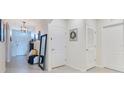 Inviting home hallway with tile flooring, neutral decor, and ample natural light from the front door at 633 Greymount St, Davenport, FL 33837