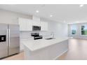 Modern kitchen featuring white cabinetry, stainless steel appliances, and a spacious island with quartz countertop at 6331 Breeze Filled Ln, Winter Garden, FL 34787