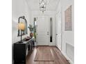 Bright foyer featuring hardwood floors, a white door with sidelights, and a stylish console table at 7191 Old Melbourne Hwy, St Cloud, FL 34771