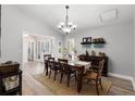 Dining room with modern light fixture, dining table, wine rack and view of front door at 8625 Vista Point Cv, Orlando, FL 32836