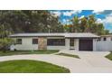 Charming single-story home with stone accents, a garage, and an expansive front yard at 1148 Northcrest Dr, Apopka, FL 32703