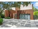 Modern home with a unique facade and multi-paned glass garage door, complemented by decorative driveway at 1742 Temple Dr, Winter Park, FL 32789