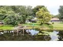Lovely backyard view with dock, lake access, lush greenery, and seating area at 2154 Lake Christie Dr, Orlando, FL 32809